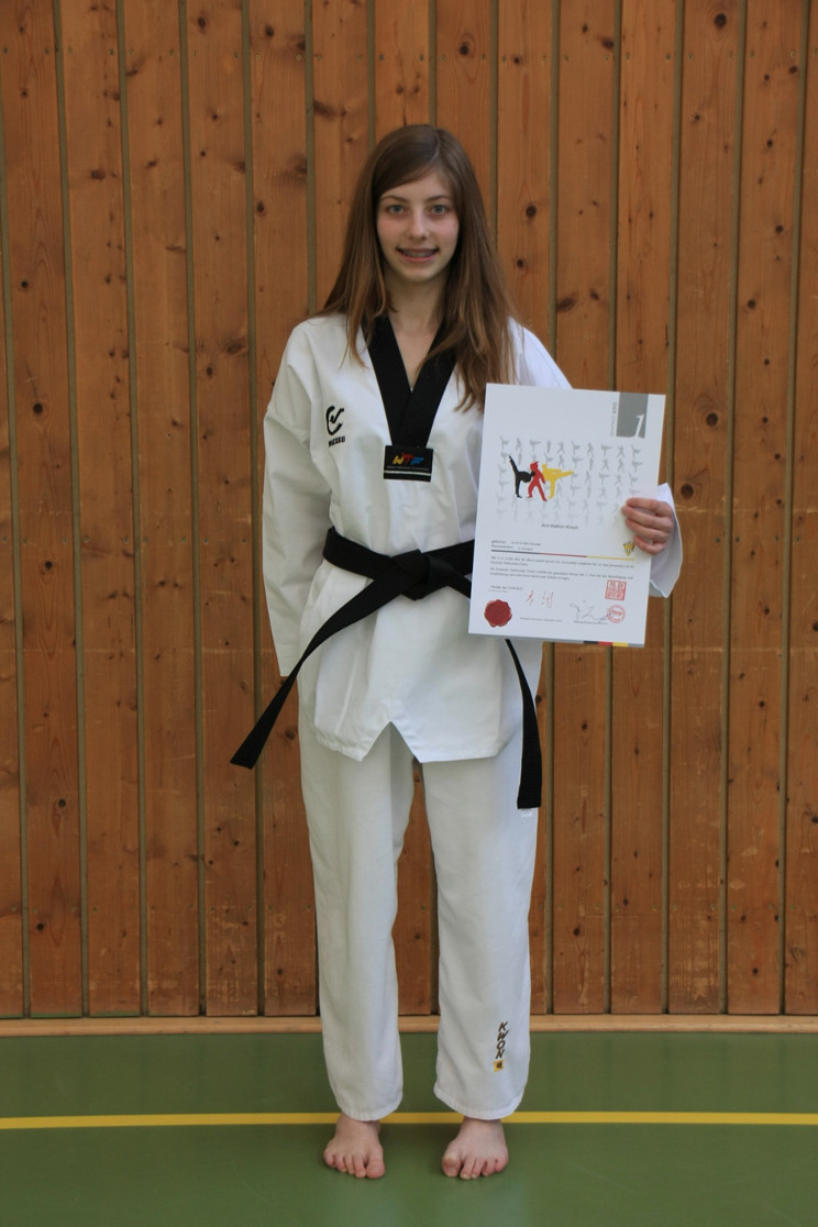 Ann-Kathrin mit ihrer Urkunde zum 1. Dan und neuem Anzug und Gürtel